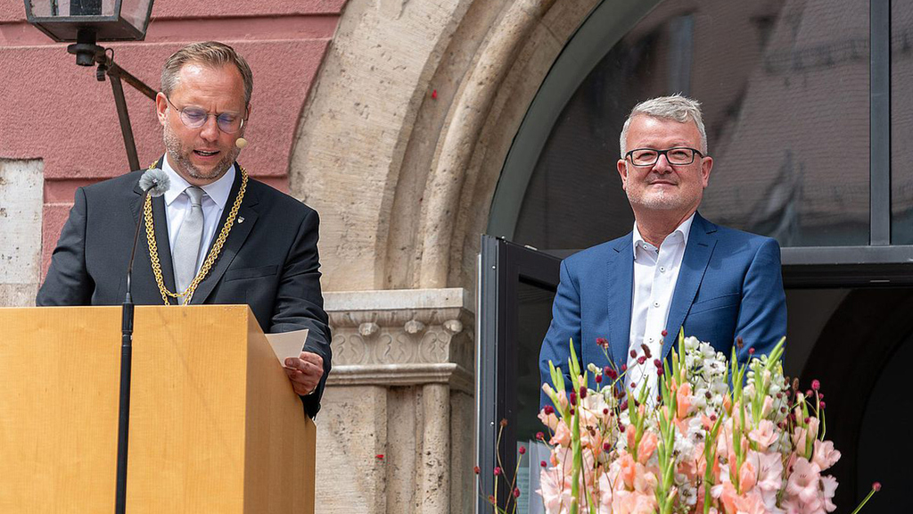 Oberbürgermeister Martin Ansbacher (links) verliest auf dem Weinhof den Urkundentext des Wissenschaftspreises 2024, mit dem die Stadt Ulm Prof. Dr. Maximilian Fichtner ehrt